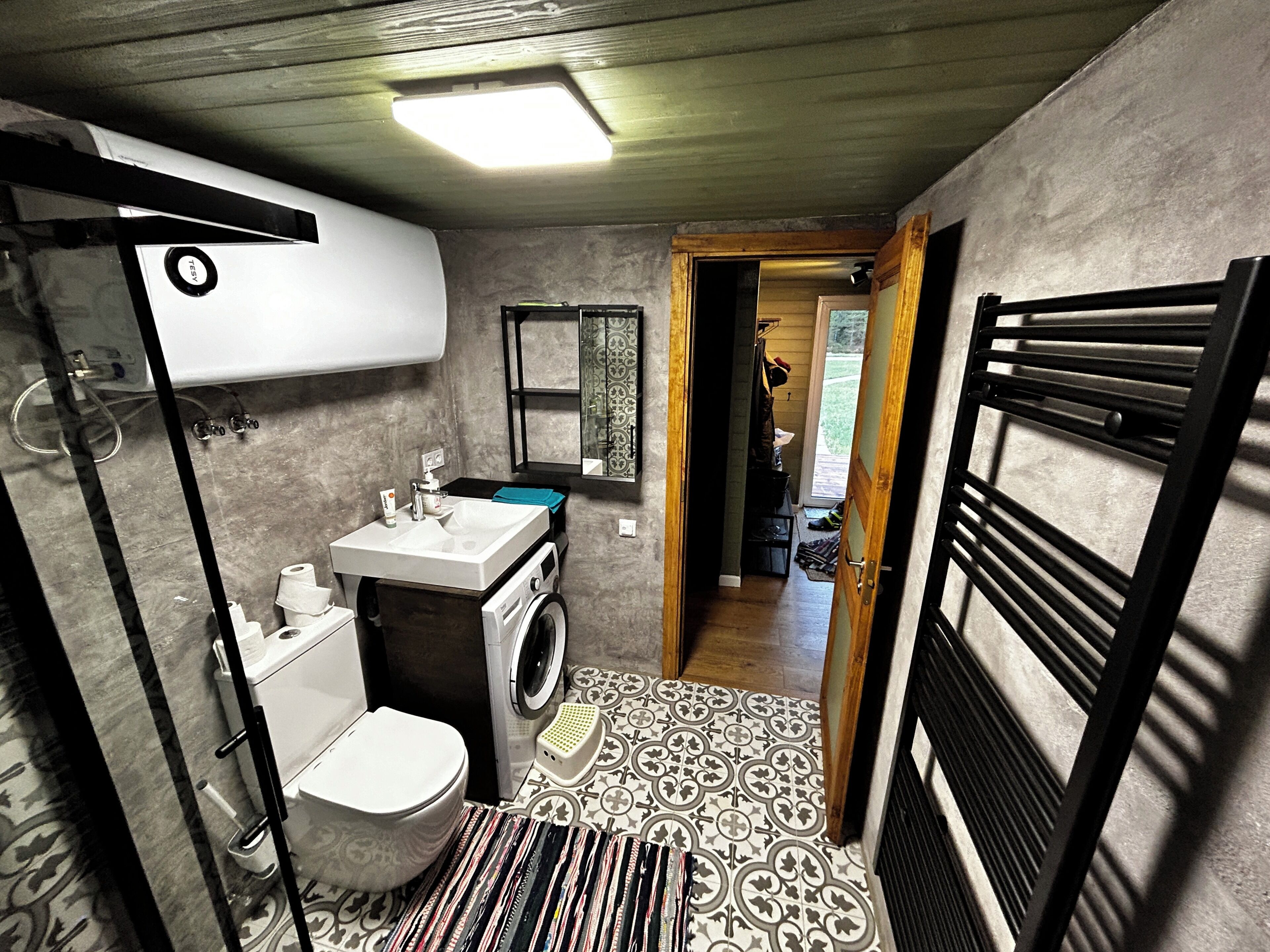 A compact bathroom with a toilet, sink, and washing machine.