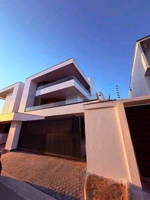 A modern building with a flat roof, a large garage door, and a paved driveway. - Paradise Bay Luxury Villa (Maputo)