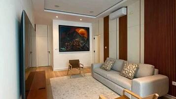 Uma sala de estar moderna com um sofá, uma mesa de centro e uma televisão.