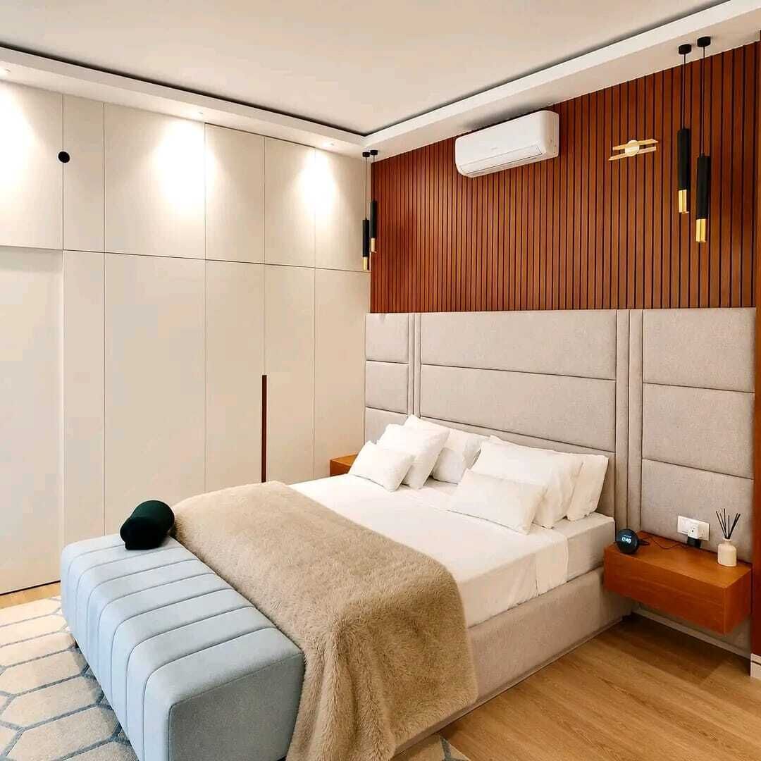 A bedroom with a bed, bedside tables, a bench, and a wardrobe.