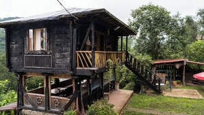 Una casa de madera con un balcón y una escalera que baja a un nivel inferior.