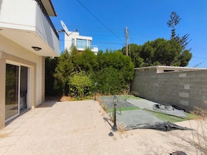 A residential property with a paved patio, a satellite dish, and a brick wall.