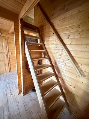 Un escalier en bois, doté d’une rampe, mène à une mezzanine.