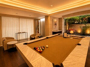 A billiards table with balls, a sofa, a small table, and a bicycle in the background. - TENNYSON HOUSE (Ciudad de México)