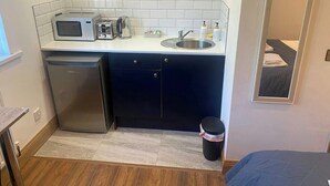 A compact kitchen with a microwave, toaster, sink, and a small refrigerator. - Accessible Double Studio | Near CBS Arena (Kitchenete (West Midlands)