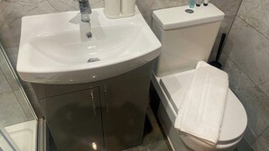 A bathroom with a sink, toilet, and a towel on the floor. - Accessible Double Studio | Near CBS Arena (Kitchenete (West Midlands)