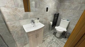 A bathroom with a marble sink, a toilet, and a towel rack. - Single Room Near CBS Arena | Free Parking (West Midlands)