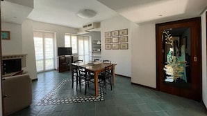A spacious living area with a dining table, chairs, and a fireplace. - Vrbo Property (Fondi)