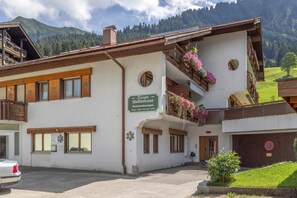 A traditional chalet with a sign indicating it is a doctor's residence. - Apartment '104 Arnika' with Mountain View, Balcony and Wi-Fi (Riezlern)