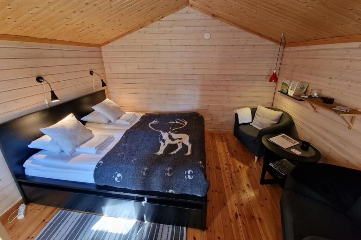 Een gezellige kamer met een bed, een kleine bank en een tafel.