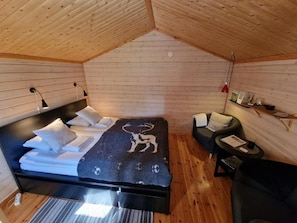 Een gezellige kamer met een bed, een kleine bank en een tafel.