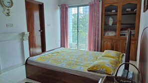 A bedroom with a bed, a wardrobe, a window with curtains, and a wall clock. - Stunning Apt in Secured Area (Dhaka)