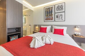 A hotel room with a bed, a minibar, a shower area, and artwork on the wall. - Premium Luxury Villa – Perfect for Families & Groups (Maputo)