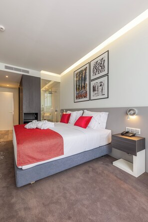 A modern hotel room with a large bed, a bedside table with a lamp, and artwork on the wall. - Premium Luxury Villa – Perfect for Families & Groups (Maputo)