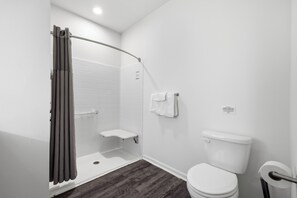 Une salle de bain équipée d’une douche, de toilettes et d’un porte-serviettes.
