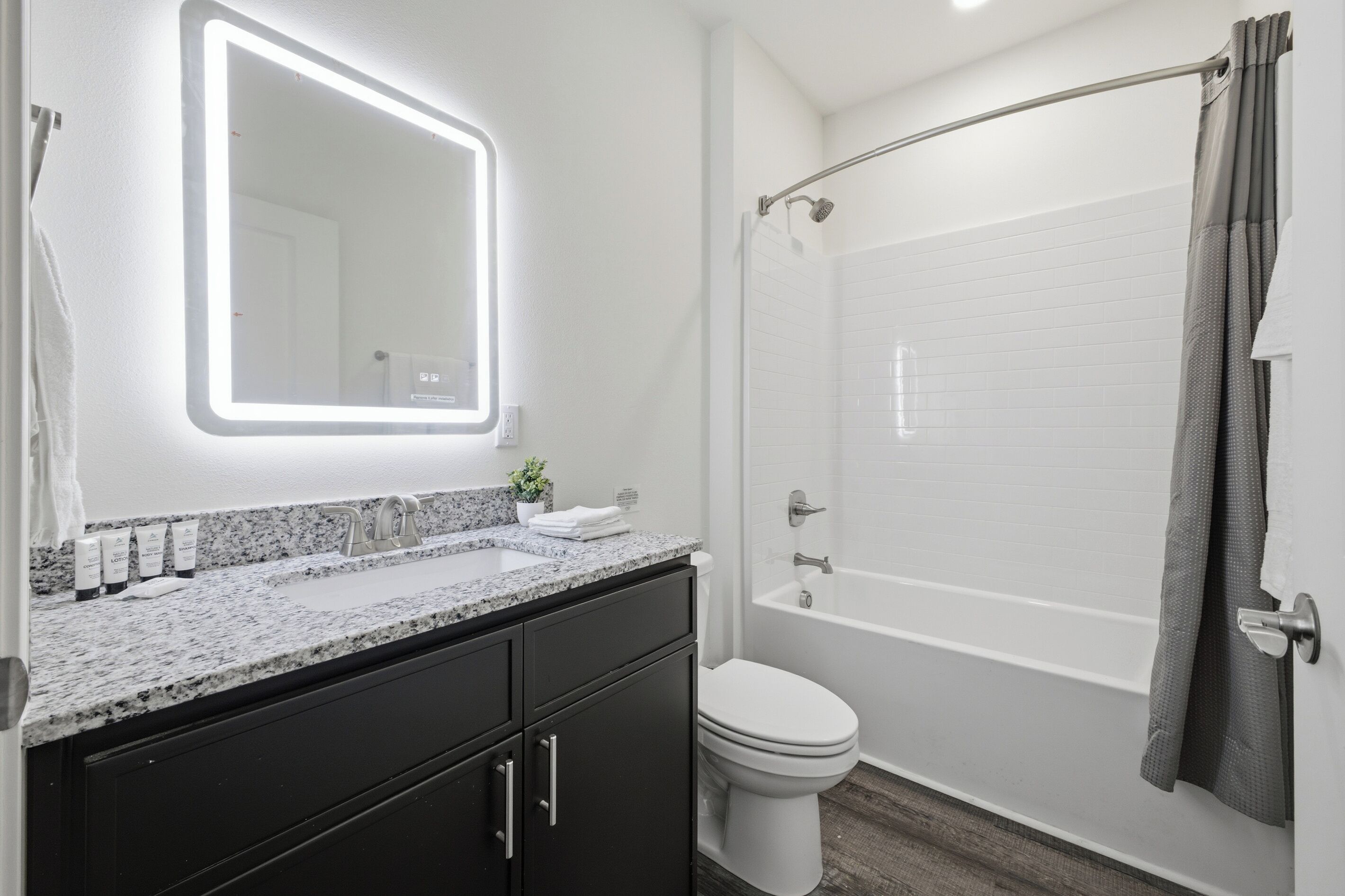 Une salle de bain moderne comprenant un meuble-lavabo, des toilettes et un espace douche.