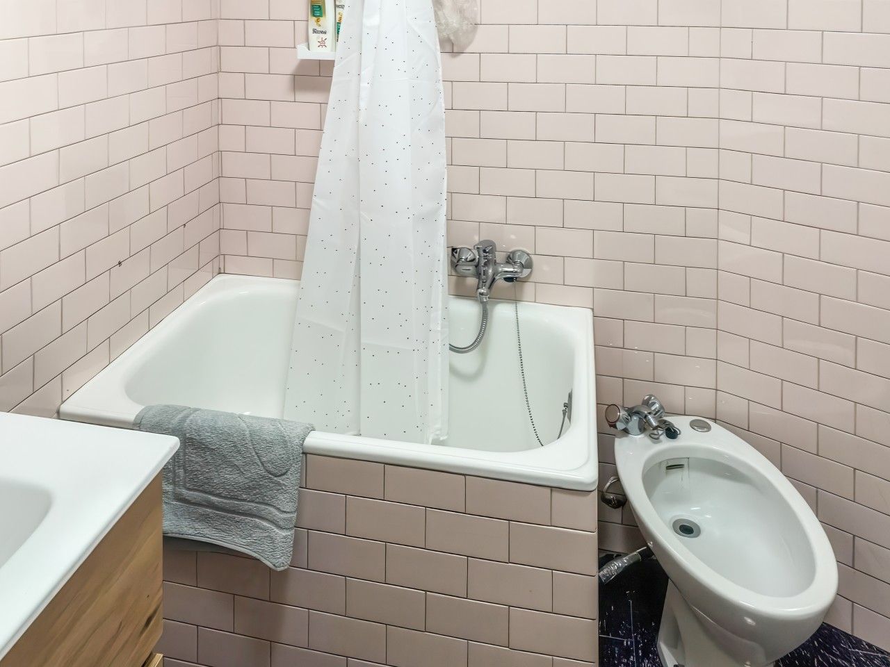 Une salle de bain avec une baignoire, un bidet et des toilettes.