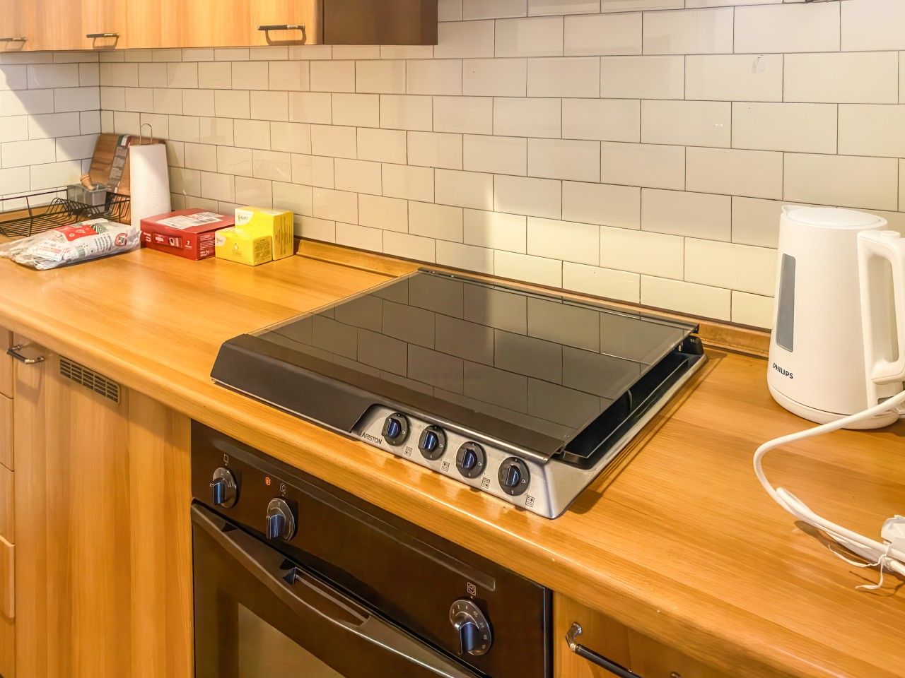 A kitchen with a built-in stove, oven, and a coffee maker on the counter.