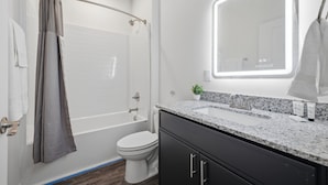 Ein modernes Badezimmer mit Dusche, Toilette und Waschtisch mit Spiegel.