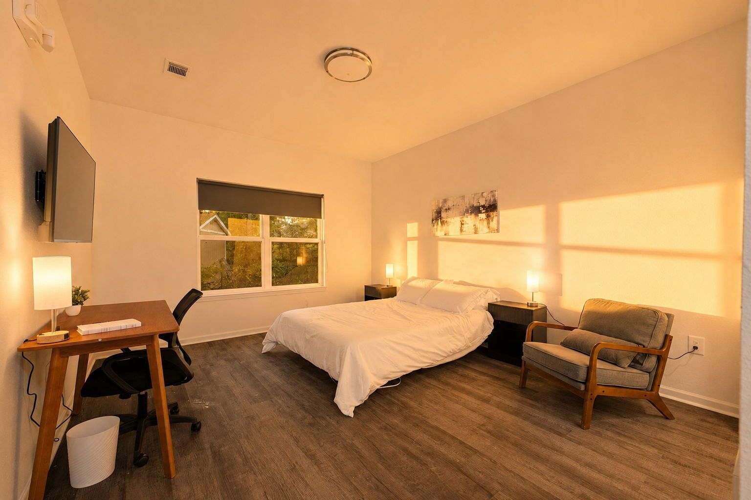 Ein Hotelzimmer mit Bett, Schreibtisch, Stuhl und einem Fenster mit Blick.