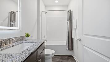 A bathroom with a shower, toilet, and sink.