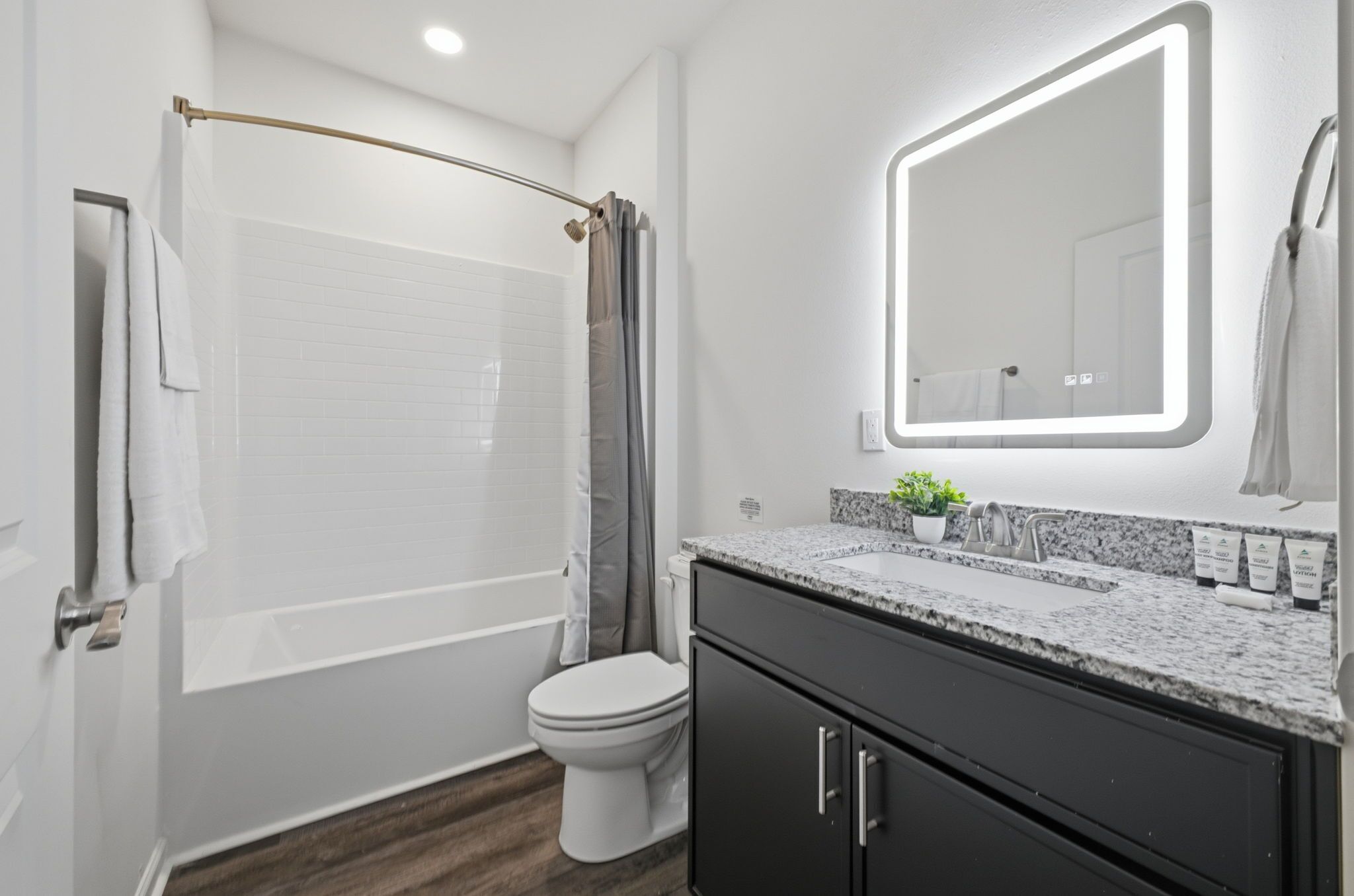 Une salle de bain moderne équipée d’une baignoire, de toilettes et d’un meuble-lavabo.