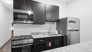 Cocina compacta con estufa, horno, lavabo y refrigerador.