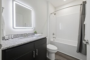 A modern bathroom with a vanity, a toilet, and a shower area.