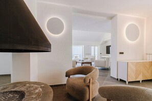 A modern interior with a fireplace, round wall lights, and a dining area. - Villa near Monte San Costanzo with pool (Massa Lubrense)