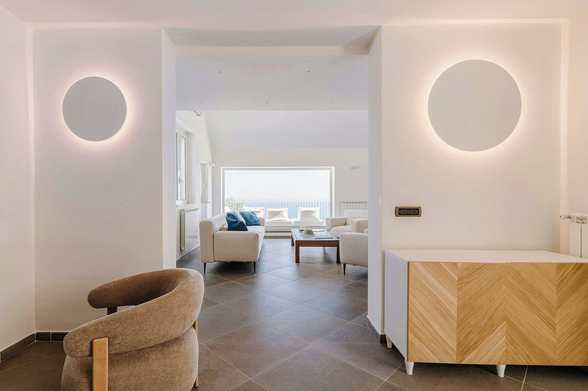 A modern interior with a central seating area, a reception desk, and a view to the outside.