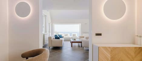 A modern interior with a central seating area, a reception desk, and a view to the outside.