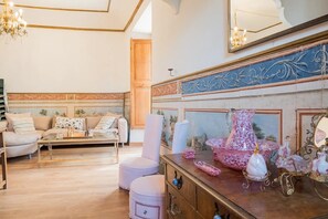 Una sala de estar bien iluminada con sofá, sillones, una mesa de centro y una chimenea decorada.