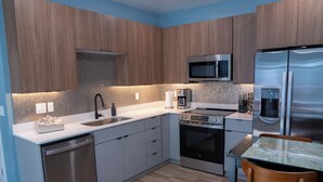 Une cuisine moderne équipée d’appareils électroménagers en acier inoxydable, d’un four à micro-ondes et d’un four encastré.