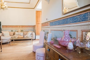 A well-lit living room with a sofa, armchairs, a coffee table, and a fireplace with decorative items. - Room 'Suite Summer' with Shared Pool, Wi-Fi and Air Conditioning (Alaró)