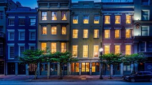 A multi-story building with illuminated windows, a sidewalk, and a street lamp. - 2BD/2BA in NOLA’s Best Walkable Neighborhood (New Orleans)