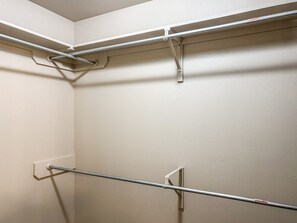 A corner of a room with a metal rod rack against the wall, a white electrical outlet, and a door frame. - Pontiac Lubbock - 3-Bedroom Home in Lubbock, Texas (Lubbock)