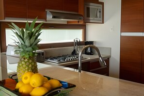 Une cuisine équipée d’une cuisinière à gaz, d’un évier en acier inoxydable et de meubles de rangement en bois.