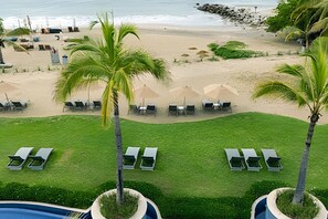 A beach resort with sun loungers, palm trees, and a pool. - 3 BR · 2 Pools · Jungle Club · Beach Club (La Cruz de Huanacaxtle)