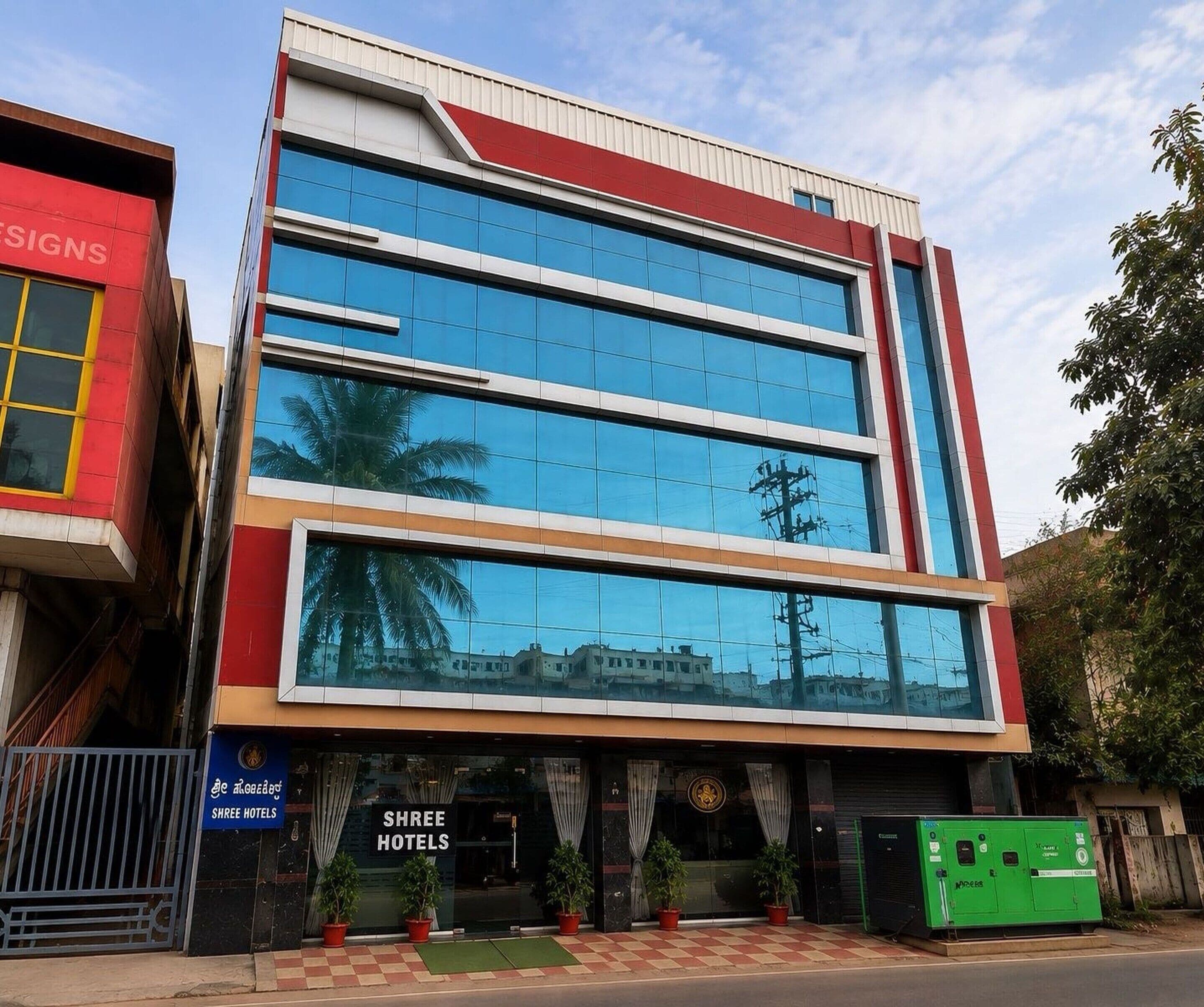 A modern hotel building with a glass facade, multiple floors, and a red and white color scheme.