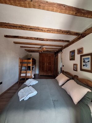 Ein Schlafzimmer mit einem Etagenbett, einem Holzschrank und einem Bett mit Kissen.