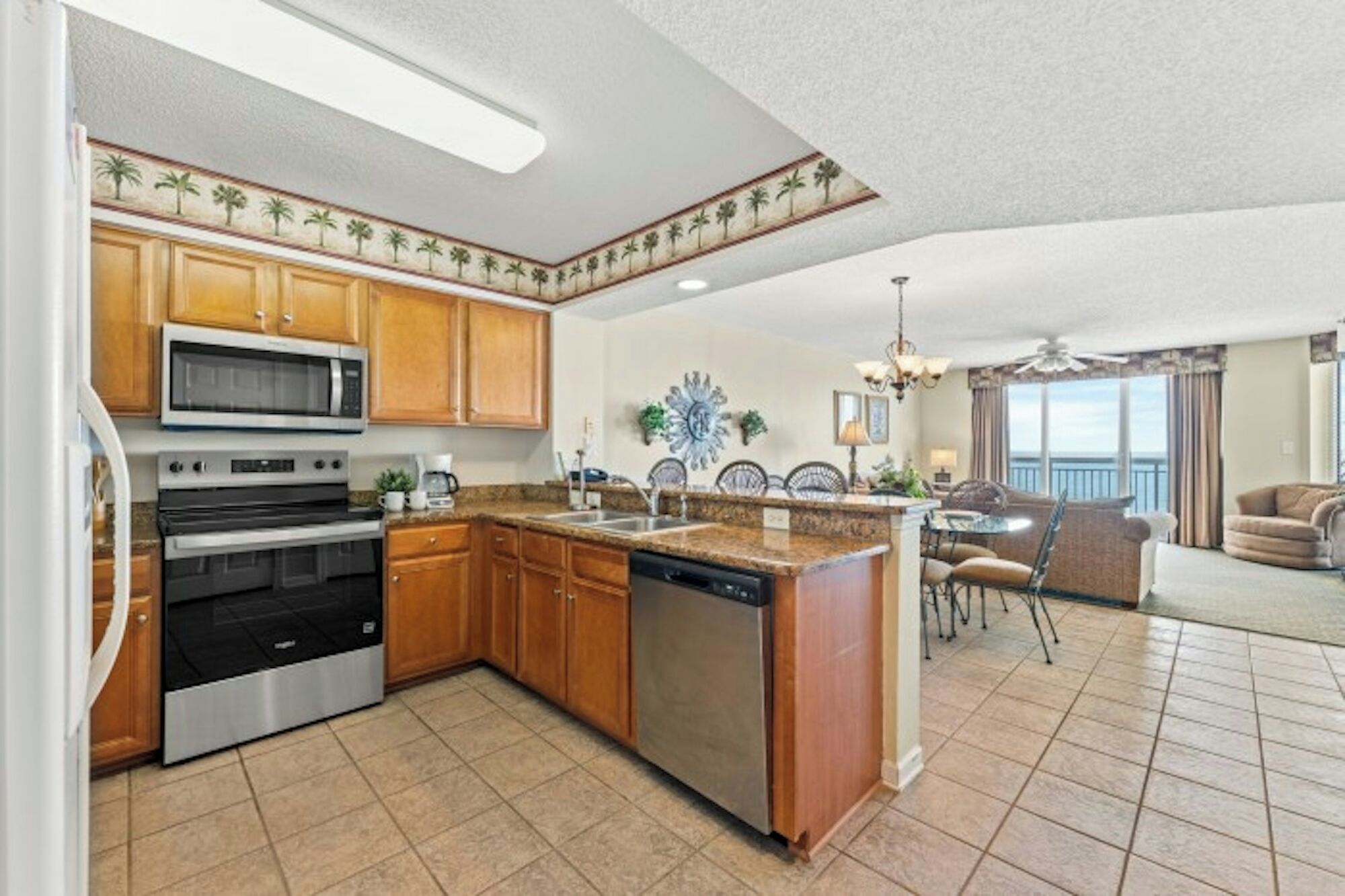 A kitchen with a central island, built-in microwave, double ovens, and wooden cabinets.