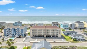 A coastal hotel with multiple buildings, a parking lot, and a view of the ocean. - Channel Marker D2- 2 BR Beach Across The Street (North Myrtle Beach)