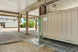 A covered outdoor area with a concrete floor, a metal ramp, and a green hose. - Channel Marker D2- 2 BR Beach Across The Street (North Myrtle Beach)