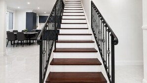 A staircase with white steps and black railings leading to an upper floor. - Luxury Family Retreat in Chipping Norton (Chipping Norton)