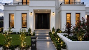 A modern two-story house with a symmetrical facade, large windows, and a well-maintained front yard. - Luxury Family Retreat in Chipping Norton (Chipping Norton)