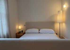 Ein Hotelzimmer mit einem Bett, zwei Nachttischlampen und einem Nachttisch.