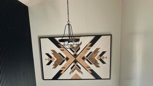 En trappa som leder upp till en dörr, ovanför vilken det finns ett geometriskt väggkonstverk.