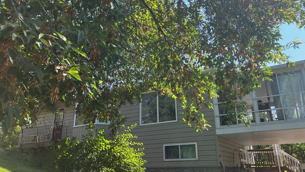 En bostadsbyggnad med en inglasad veranda, en trappa och ett väl synligt fönster.