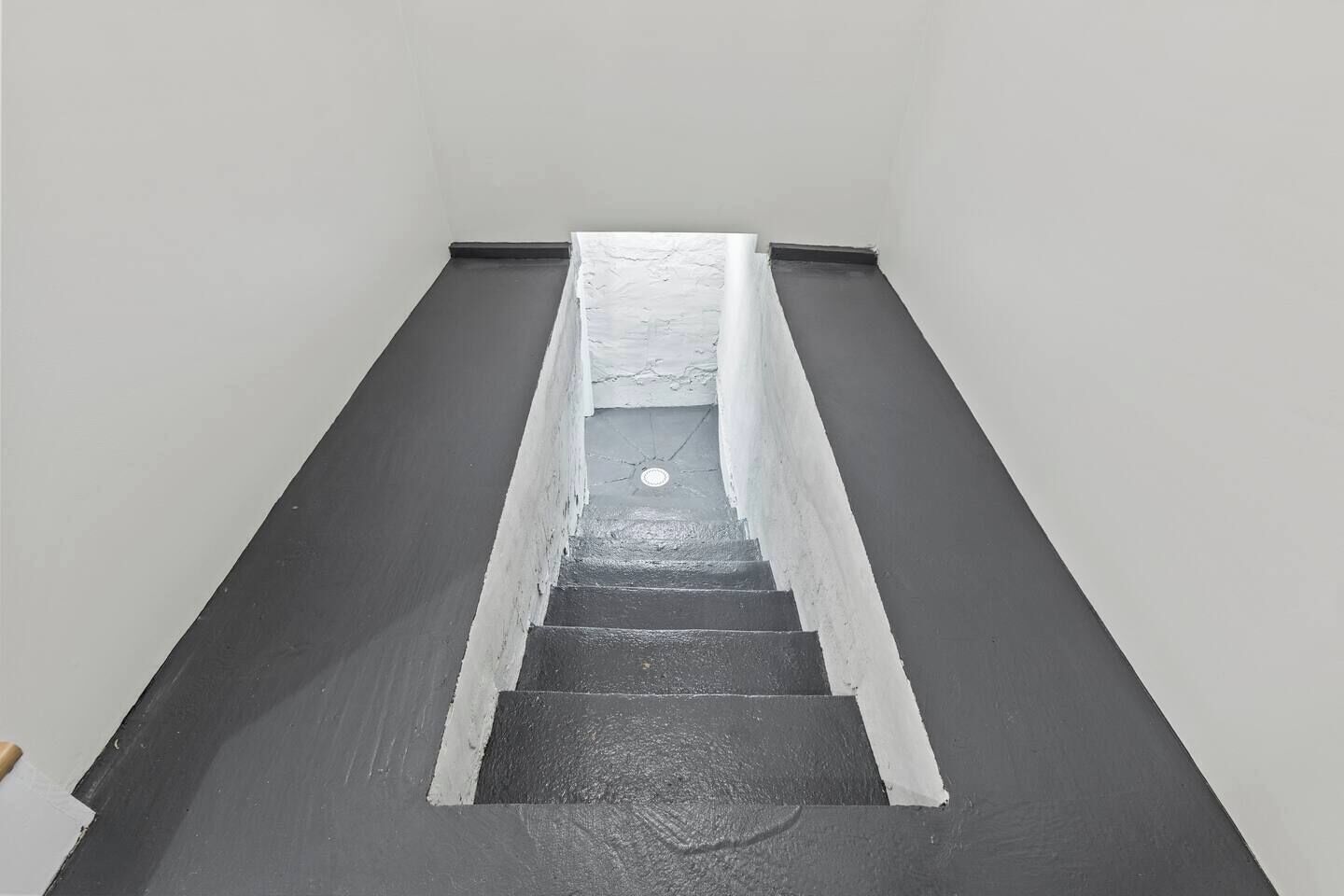Uma escadaria em esquema de cores preto e branco, que leva a um andar superior.