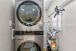 Cuina compacta amb forn integrat, microones i campana extractora d'acer inoxidable.